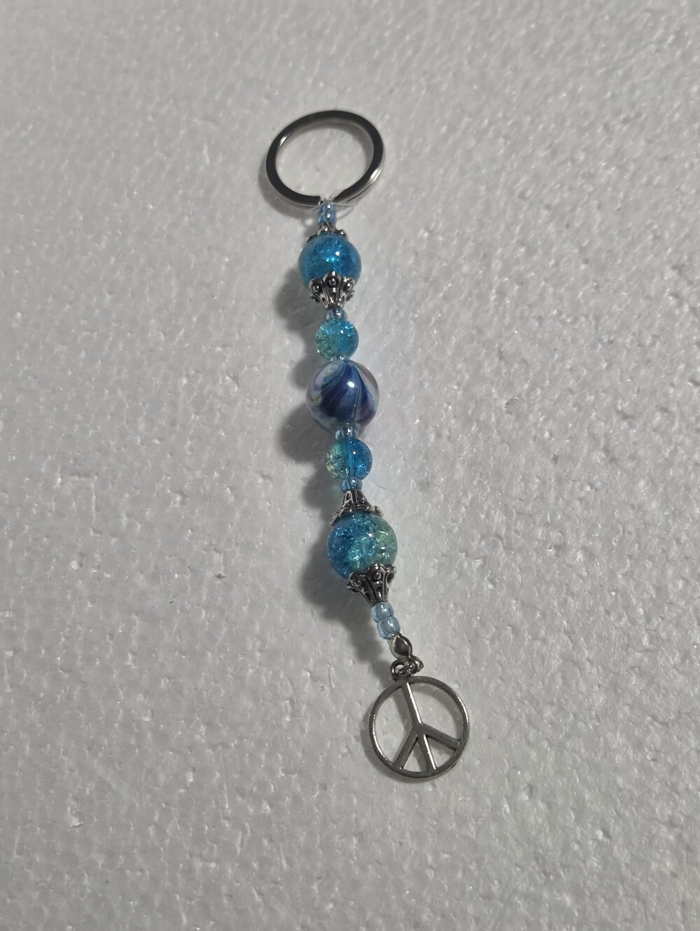 Handcrafted Blue And Silver Key Chain With A Peace Sign Charm